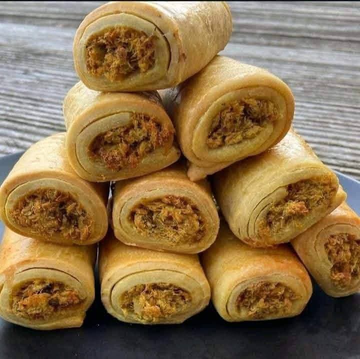 A stack of homemade sausage rolls with golden pastry and seasoned filling