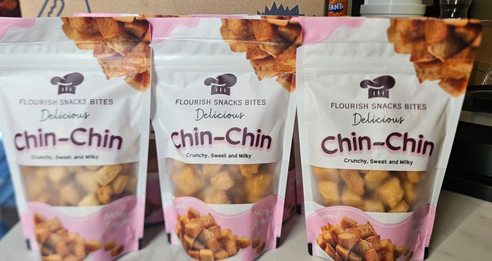 Three sealed pouches of Flourish Snacks Bites chin chin